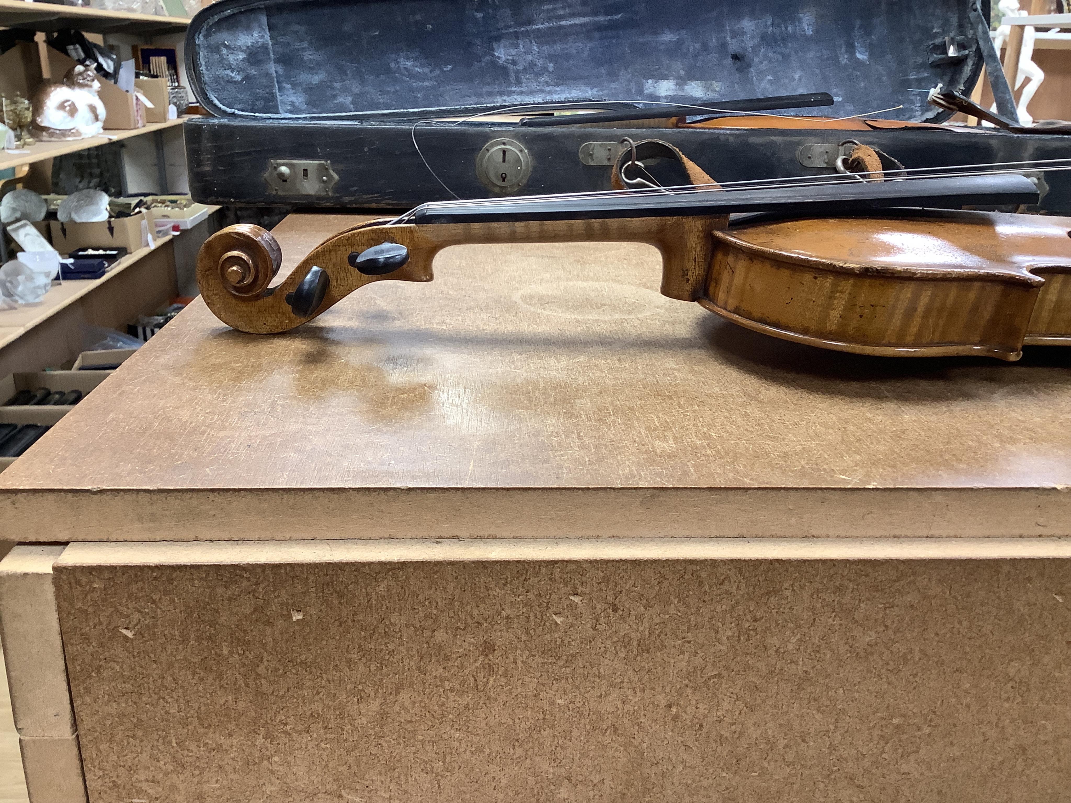 A cased 7/8 size 19th century violin, body 35cm, together with another cased violin, body 35.5cm, both without bows, and a spare case (3)